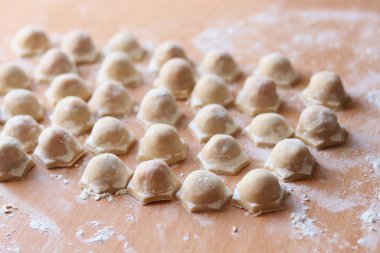 Ahşap arka planda el yapımı çiğ Rus pelmeni. Un görünümlü ahşap arkaplan