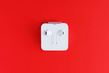 Kırmızı arkaplandaki kulaklıklar izole edildi.