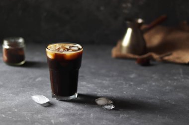 Süt koyu arka planda buzlu kahveye dökülüyor. Buzlu kahve..