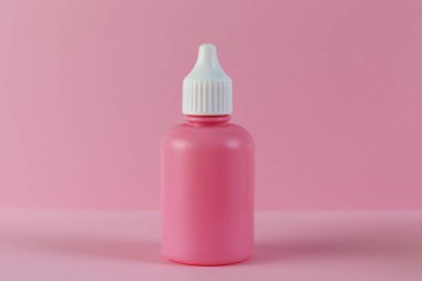 Pembe arka planda kozmetik pembe şişe