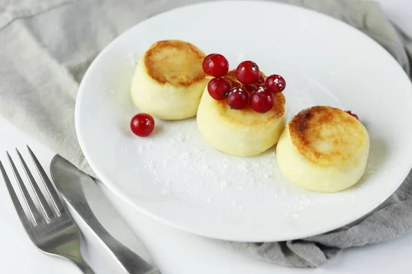 Cottage cheese pancakes with fresh currants. Russian syrniki or sirniki, cottage cheese fritters or pancakes served with berries. Restaurant menu, cookbook recipe. Top view, copy space