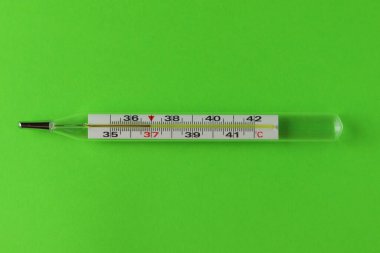 Tıbbi cıva termometresi yeşil arka planda izole edildi