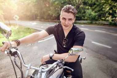               Motosiklette oturan bir adamın portresi.                                                