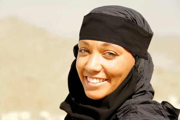 Doğal ortamda gülümseyen genç Müslüman kadın portresi