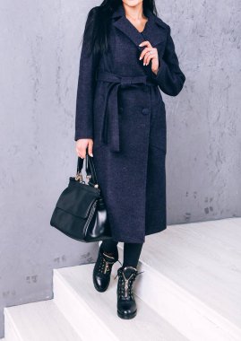 Yarı sezon kıyafetlerinin stüdyo fotoğrafçılığı. Gri arka planda zarif ceketli genç bir kız. Promosyon kadın ceketi. Şık bir sonbahar bahar montu giymiş bir kadın. Günlük kıyafet..