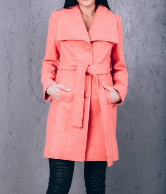 Dış giyimin ayrıntıları yakın plan. Yarı sezon kıyafetlerinin stüdyo fotoğrafçılığı. Gri arka planda zarif ceketli genç bir kız. Promosyon kadın ceketi. Şık bir sonbahar bahar montu giymiş bir kadın..