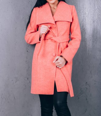 Dış giyimin ayrıntıları yakın plan. Yarı sezon kıyafetlerinin stüdyo fotoğrafçılığı. Gri arka planda zarif ceketli genç bir kız. Promosyon kadın ceketi. Şık bir sonbahar bahar montu giymiş bir kadın..