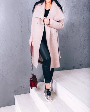 Yarı sezon kıyafetlerinin stüdyo fotoğrafçılığı. Gri arka planda zarif ceketli genç bir kız. Promosyon kadın ceketi. Şık bir sonbahar bahar montu giymiş bir kadın. Günlük kıyafet..