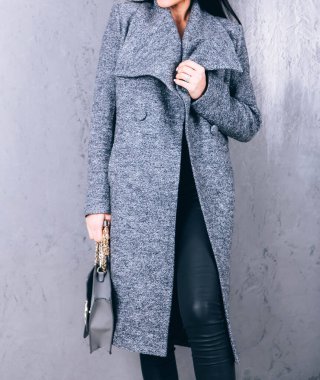 Yarı sezon kıyafetlerinin stüdyo fotoğrafçılığı. Gri arka planda zarif ceketli genç bir kız. Promosyon kadın ceketi. Şık bir sonbahar bahar montu giymiş bir kadın. Günlük kıyafet..