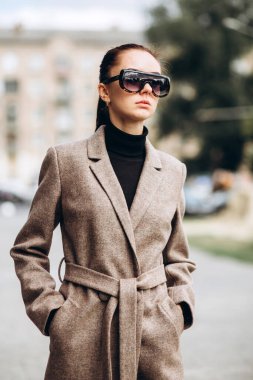 Kadın ceketinin ayrıntıları yakın plan. Açık havada zarif ceketli genç bir kız. Promosyon kadın ceketi. Havalı, yünlü bir sonbahar ve bahar ceketli, şık, esmer bir kadın..