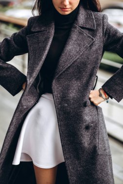 Kadın ceketinin ayrıntıları yakın plan. Açık havada zarif ceketli genç bir kız. Promosyon kadın ceketi. Havalı, yünlü bir sonbahar ve bahar ceketli, şık, esmer bir kadın..