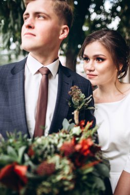 Güneşli bir sonbahar gününde gelinlik giymiş genç bir çift şehirde dolaşıyor. Duygular. Yeşillik arka planında mutlu bir karı kocanın portresi. Komik adam ve kız dışarıda gülüyorlar..