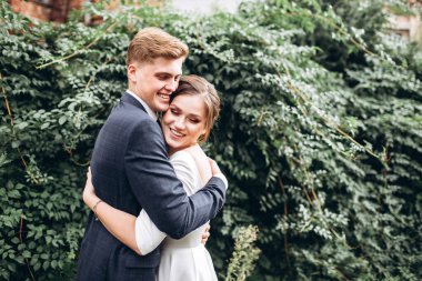 Güneşli bir sonbahar gününde gelinlik giymiş genç bir çift şehirde dolaşıyor. Duygular. Yeşillik arka planında mutlu bir karı kocanın portresi. Komik adam ve kız dışarıda gülüyorlar..