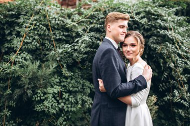 Güneşli bir sonbahar gününde gelinlik giymiş genç bir çift şehirde dolaşıyor. Duygular. Yeşillik arka planında mutlu bir karı kocanın portresi. Komik adam ve kız dışarıda gülüyorlar..