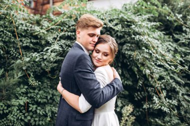 Güneşli bir sonbahar gününde gelinlik giymiş genç bir çift şehirde dolaşıyor. Duygular. Yeşillik arka planında mutlu bir karı kocanın portresi. Komik adam ve kız dışarıda gülüyorlar..