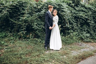 Güneşli bir sonbahar gününde gelinlik giymiş genç bir çift şehirde dolaşıyor. Duygular. Yeşillik arka planında mutlu bir karı kocanın portresi. Komik adam ve kız dışarıda gülüyorlar..