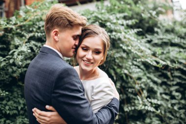 Güneşli bir sonbahar gününde gelinlik giymiş genç bir çift şehirde dolaşıyor. Duygular. Yeşillik arka planında mutlu bir karı kocanın portresi. Komik adam ve kız dışarıda gülüyorlar..