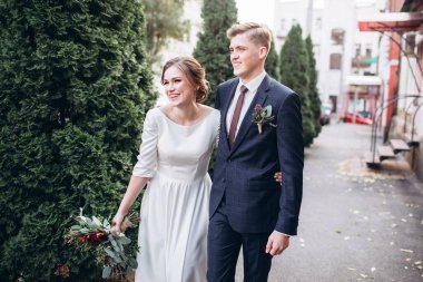 Sonbahar günü şehirde yürüyen genç bir çift. Birbirine aşık bir çift. Gerçek duygular. Yeşillik arka planında mutlu bir karı kocanın portresi. Komik adam ve kız yağmurda dışarıda gülüyorlar..