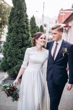 Sonbahar günü şehirde yürüyen genç bir çift. Birbirine aşık bir çift. Gerçek duygular. Yeşillik arka planında mutlu bir karı kocanın portresi. Komik adam ve kız yağmurda dışarıda gülüyorlar..