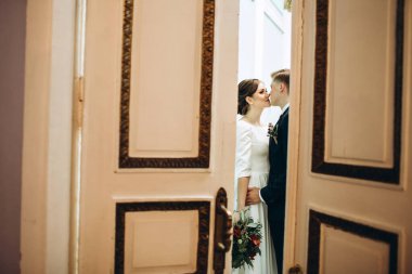 Eski bir malikanede gelinlik giymiş genç bir çift. Gelin ve damat içeride bir düğün töreninde. Sevgi dolu bir çift. Duygular. Mutlu karı koca. Elinde bir buket sonbahar çiçeğiyle gelin..