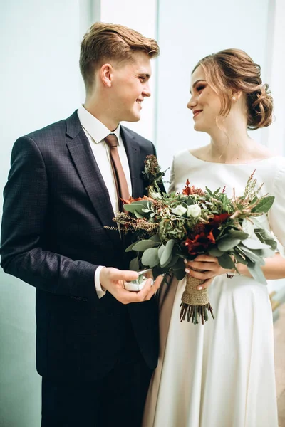 Eski bir malikanede gelinlik giymiş genç bir çift. Gelin ve damat içeride bir düğün töreninde. Sevgi dolu bir çift. Duygular. Mutlu karı koca. Elinde bir buket sonbahar çiçeğiyle gelin..