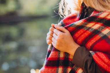 Gri şapkalı sarışın sonbahar ormanında yürüyor. Kırmızı kareli eşarplı neşeli kız sarı ormanın arka planında duruyor. Sonbaharda bir kızın yakın plan portresi. Bulanık arkaplan