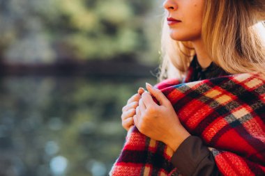 Gri şapkalı sarışın sonbahar ormanında yürüyor. Kırmızı kareli eşarplı neşeli kız sarı ormanın arka planında duruyor. Sonbaharda bir kızın yakın plan portresi. Bulanık arkaplan