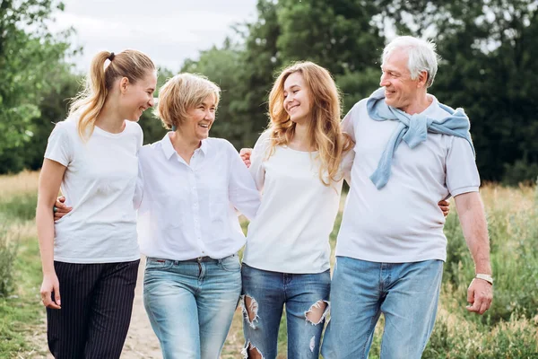 Yetişkin kızları olan yaşlı bir çift doğada yürür. Olgun bir çift ormanda yürüyor. Beyaz tişörtlü ve kot pantolonlu bir aile parkta yürüyor. Mutlu bir aile. Aile dışarıda iletişim kurar.
