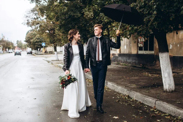 若い幸せなカップルは雨の後 街の通りを歩いている 傘を持っている男と女のクローズアップ肖像画 屋外で笑っているカップルを愛する 男が通りを歩いて傘を振って — ストック写真
