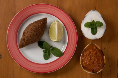 Kızarmış kibbeh yoğurt sosu, limon ve biber sosuyla servis edilir. Üst Görünüm 