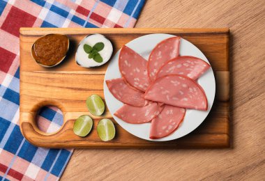 MORTADELLA SLICES APPETIZER, SERVED WITH LEMON AND PEPPER SAUCE clipart