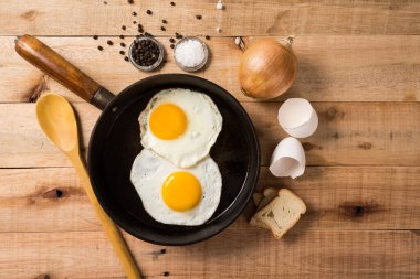 Kızarmış yumurta, tavada, ahşap arka planda. Üst Wiew.