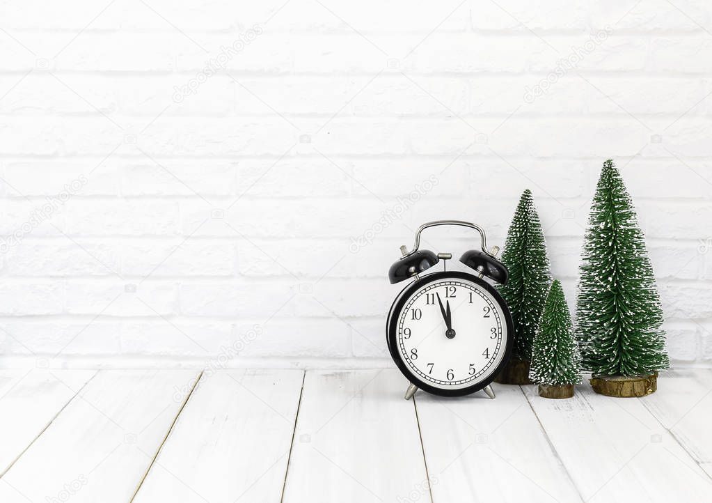 alarm clock and christmas tree on white wood table over white background with copy space