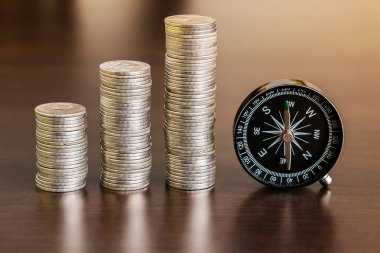 Tahta masanın üzerinde pusula olan bozuk paralar yığını