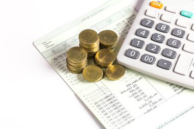 Hesap makineli altın sikkeler ve beyaz zemin üzerine kitap bankası