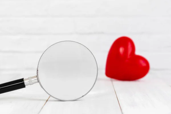 Magificação Vidro Com Coração Vermelho Forma Fundo Branco Encontrar Conceito — Fotografia de Stock