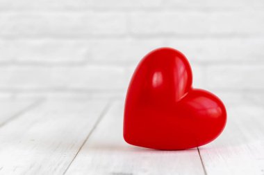 Beyaz ahşap zemin üzerinde kopyalama alanı ile şekillendirilmiş kırmızı kalp