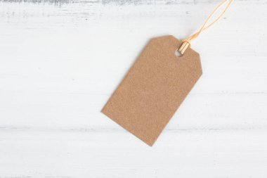 Beyaz tahta üzerinde kahverengi el işi kağıt etiketi beyaz tuğla torba