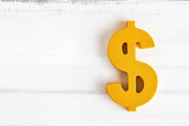 Kopya alanı olan beyaz ahşap masada dolar işareti.