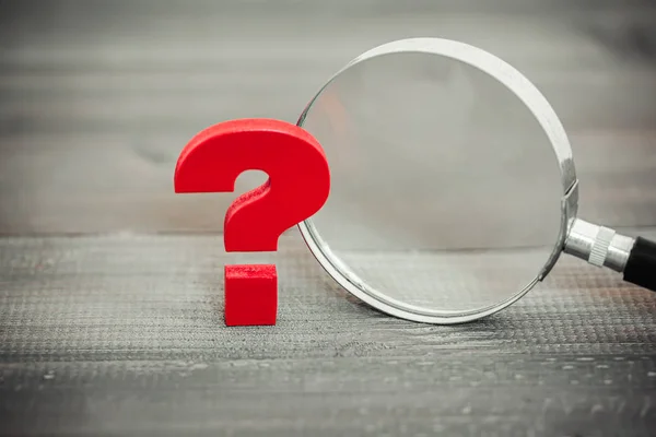 Red Question mark with magnifying glass on wood table — 图库照片