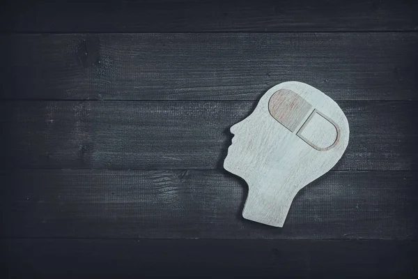 Kepala dan wajah manusia dengan tanda obat di meja kayu latar belakang. — Stok Foto