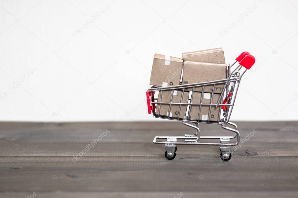 Shipping Box with shopping cart trolley on wood table