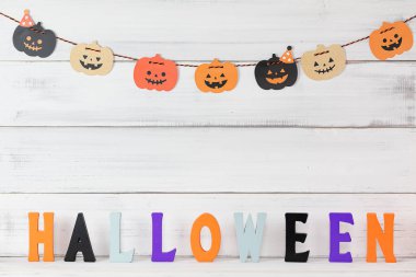 Cadılar Bayramı balkabağı süslemesi beyaz ahşap arka planda ve izin