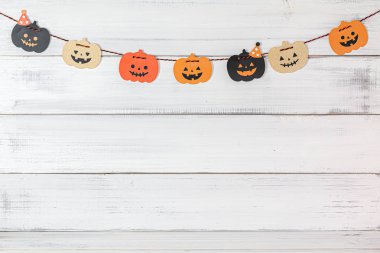 Cadılar Bayramı balkabağı süslemesi beyaz ahşap arka planda.