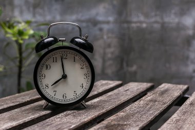 Ahşap masa üzerinde siyah çalar saat