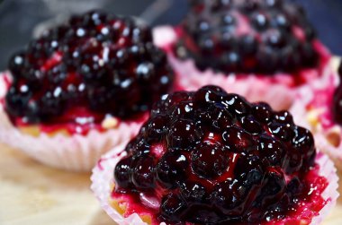 Kızılcık reçeli ve nugat dolu sert kağıt sepetler içinde kek.