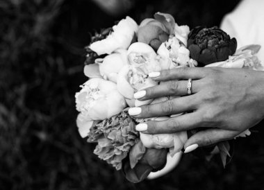 Gelinler, şakayık demetinde beyaz altın elmaslarla zarif bir alyansla el ele tutuşurlar.