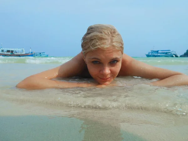 Giovane abbronzata donna magra in costume da bagno è sdraiato sulla sabbia sulla spiaggia. l'oceano dietro, thailandia, abbronzatura, vacanza — Foto Stock