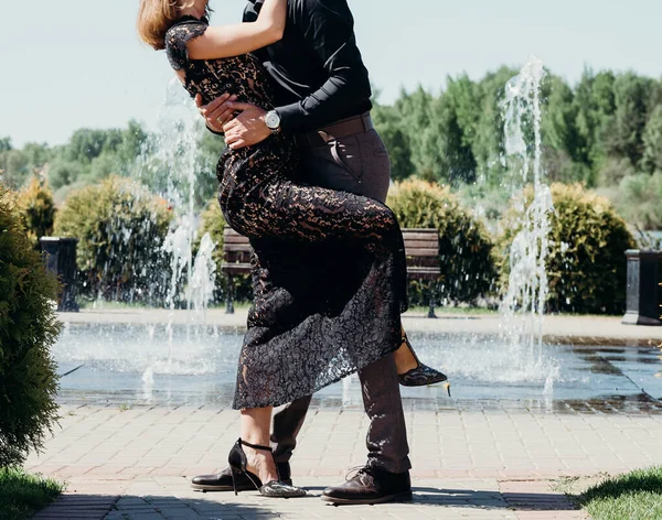 Joven pareja mujer en un largo elegante encaje vestido negro hombre en pantalones y camisa. historia de amor al aire libre, ternura, abrazos — Foto de Stock
