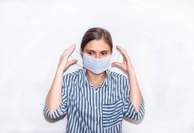 Mavi çizgili gömlekli, maskeli genç bir kadın. Koronavirüs için tedavi, salgın, covid 19, zatürree.. 